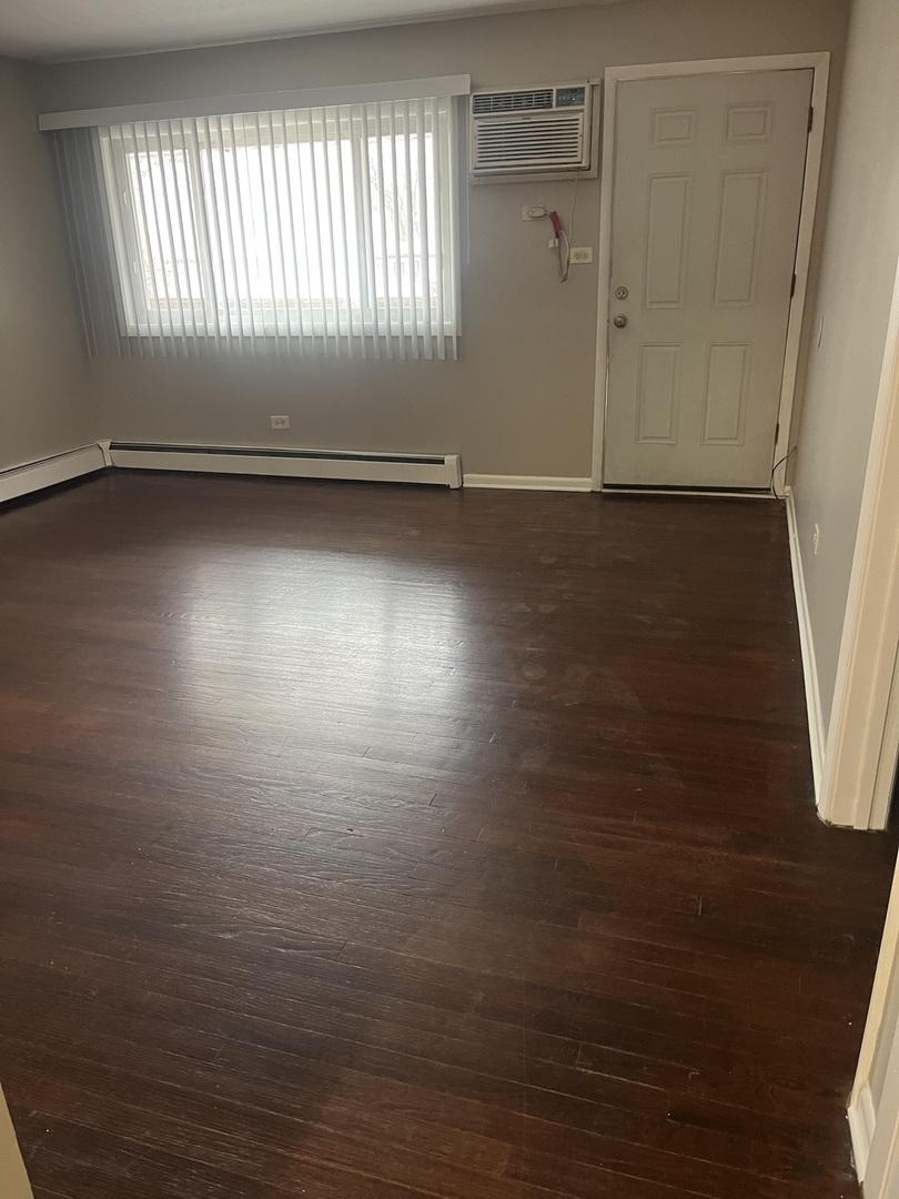 8817 South Roberts Road, Unit 11 Hickory Hills, IL 60457 - Photo 5 of 7 an empty room with wooden floor and windows