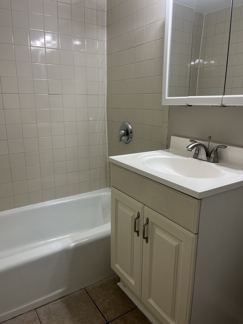 8817 South Roberts Road, Unit 11 Hickory Hills, IL 60457 - Photo 6 of 7 a bathroom with a sink vanity tub and shower