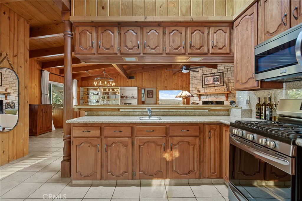 31466 Frontier Drive Running Springs, CA 92382 - Photo 13 of 43 a kitchen with stainless steel appliances granite countertop a stove and cabinets