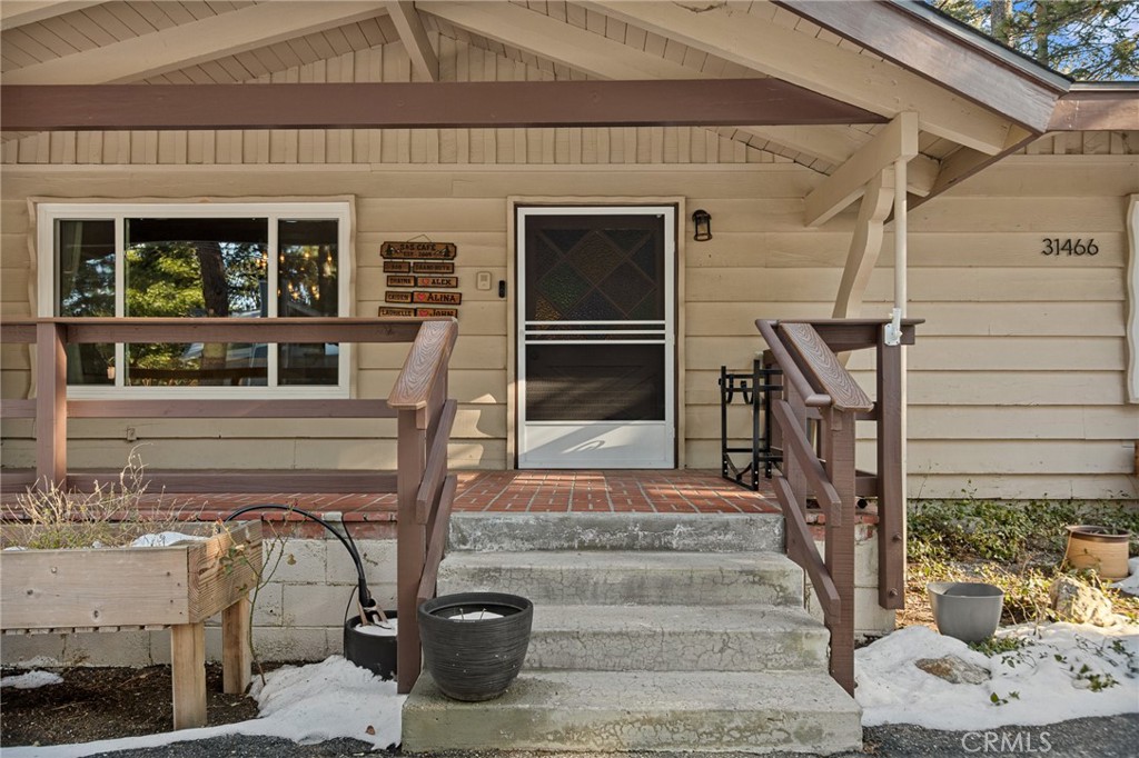 31466 Frontier Drive Running Springs, CA 92382 - Photo 5 of 43 a front view of a house with wooden stairs