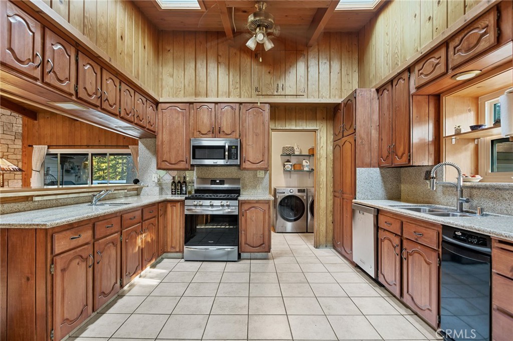 31466 Frontier Drive Running Springs, CA 92382 - Photo 9 of 43 a kitchen with stainless steel appliances a sink a stove top oven a counter space and cabinets