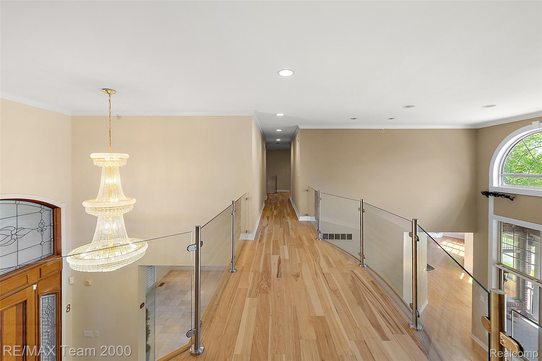 630 Sheldon Court Rochester, MI 48306 - Photo 54 of 94 Corridor featuring light wood-type flooring, crown molding, and a chandelier