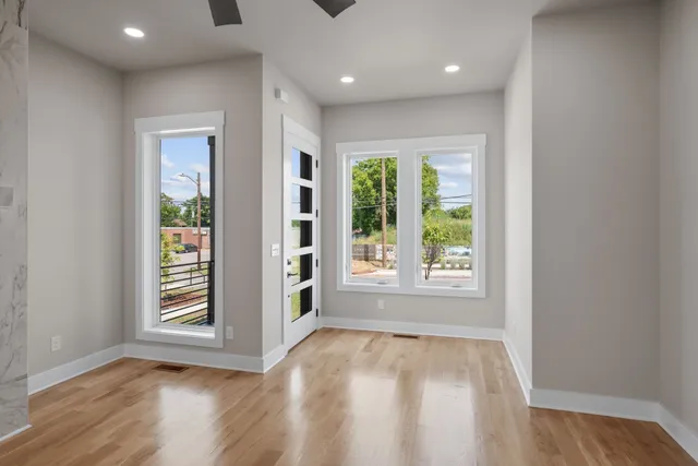 an empty room with wooden floor and windows
