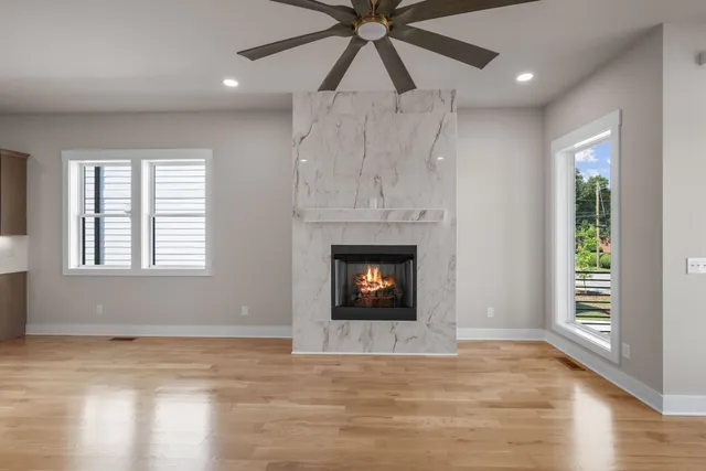 an empty room with windows and fireplace