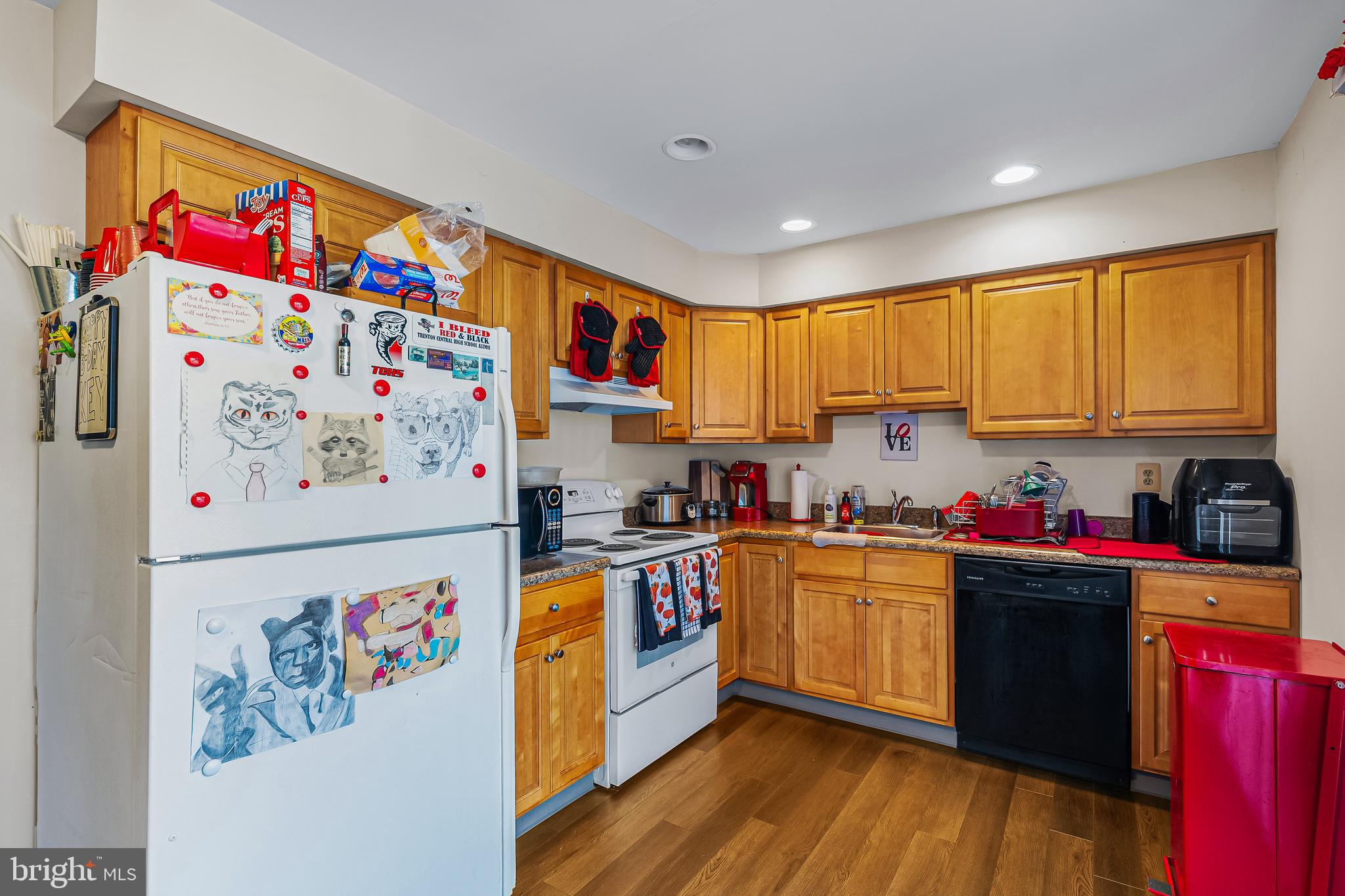 144 New Cedar Lane Hamilton, NJ 08610 - Photo 24 of 48 a kitchen with granite countertop a white refrigerator a sink dishwasher and wooden cabinets with wooden floor