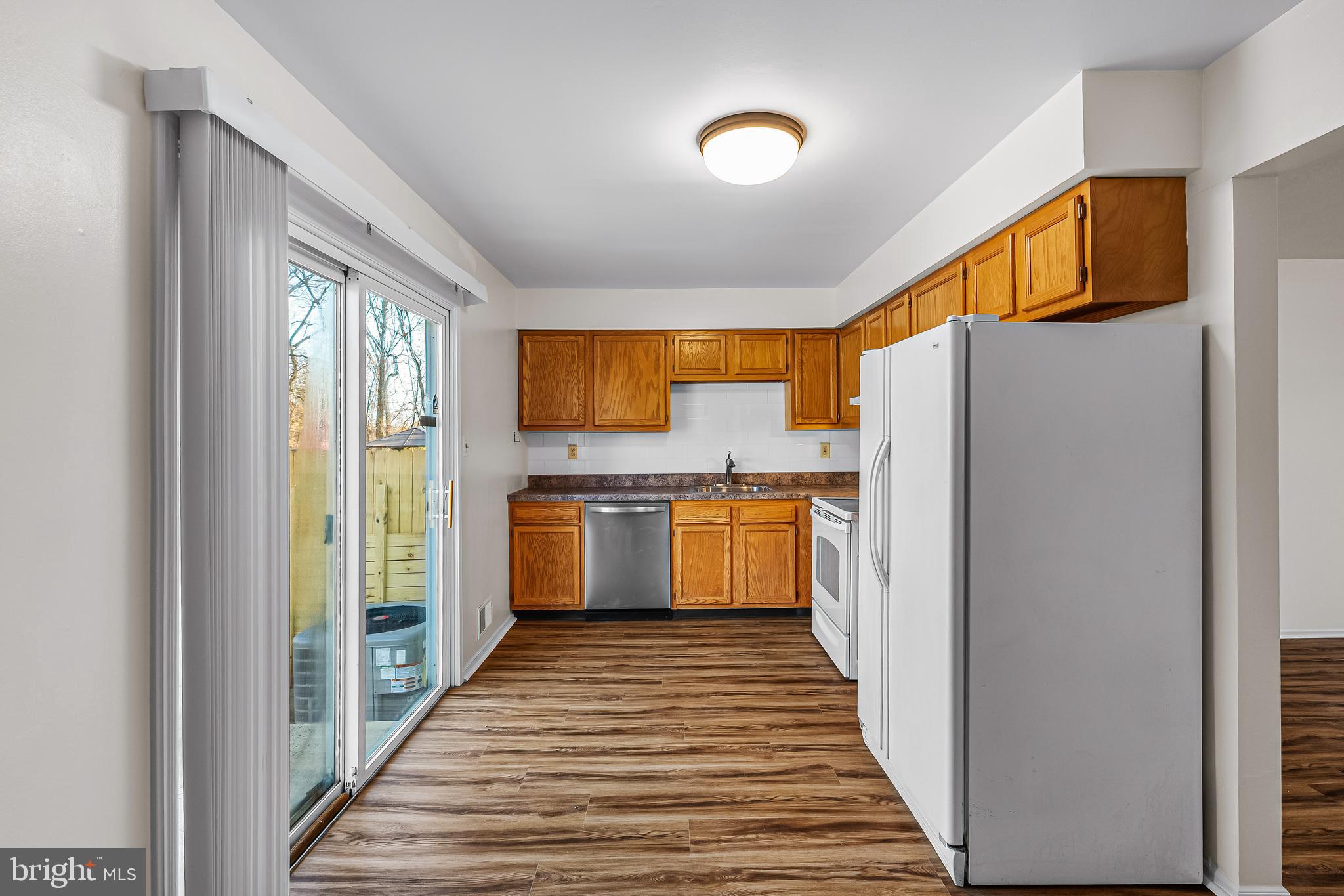 144 New Cedar Lane Hamilton, NJ 08610 - Photo 27 of 48 a kitchen with a refrigerator a sink and dishwasher with wooden floor