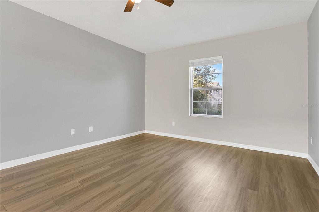 1621 Reflection Cove St. Cloud, FL 34771 - Photo 11 of 35 a view of an empty room with wooden floor and a window