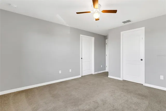an empty room with chandelier fan