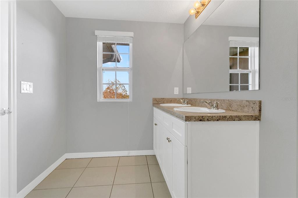 1621 Reflection Cove St. Cloud, FL 34771 - Photo 16 of 35 a bathroom with a sink and a mirror