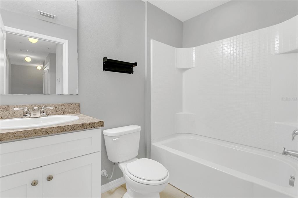 1621 Reflection Cove St. Cloud, FL 34771 - Photo 19 of 35 a bathroom with a sink a toilet and a bathtub