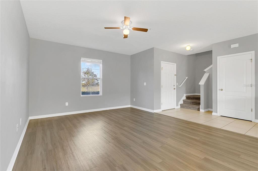 1621 Reflection Cove St. Cloud, FL 34771 - Photo 3 of 35 a view of an empty room with wooden floor and a ceiling fan