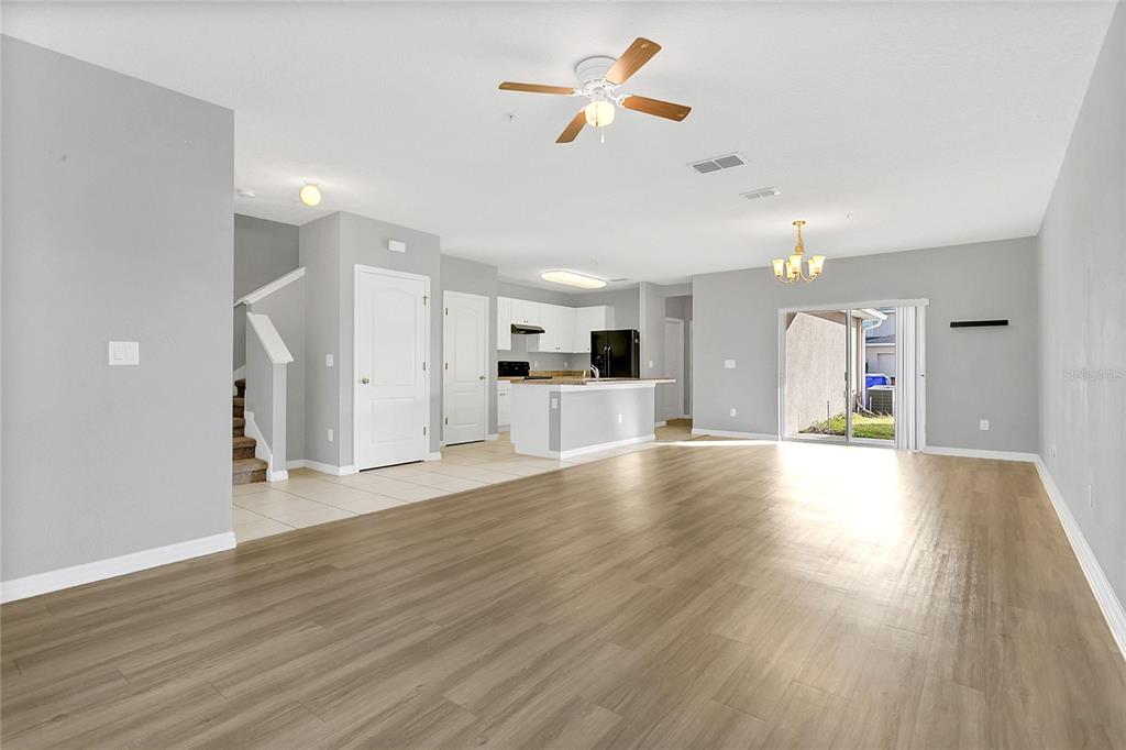 1621 Reflection Cove St. Cloud, FL 34771 - Photo 6 of 35 a view of an empty room and kitchen with wooden floor