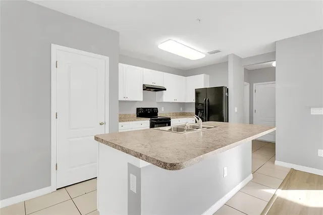 a kitchen with stainless steel appliances granite countertop a sink and a refrigerator
