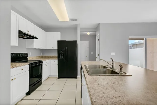 a kitchen with a sink a counter top space cabinets and stainless steel appliances