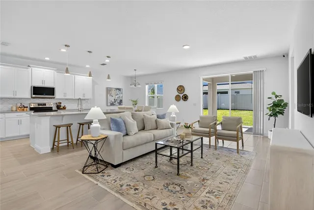 a living room with furniture and a view of kitchen