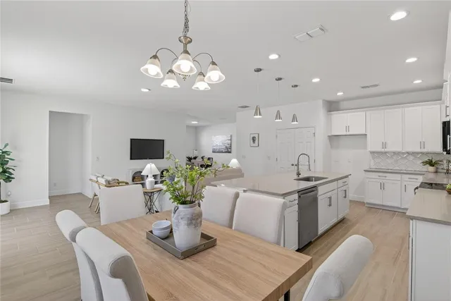 a kitchen with a dining table wooden floor and living room