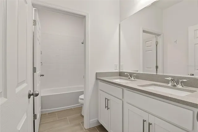 a bathroom with a granite countertop sink a mirror and a bathtub