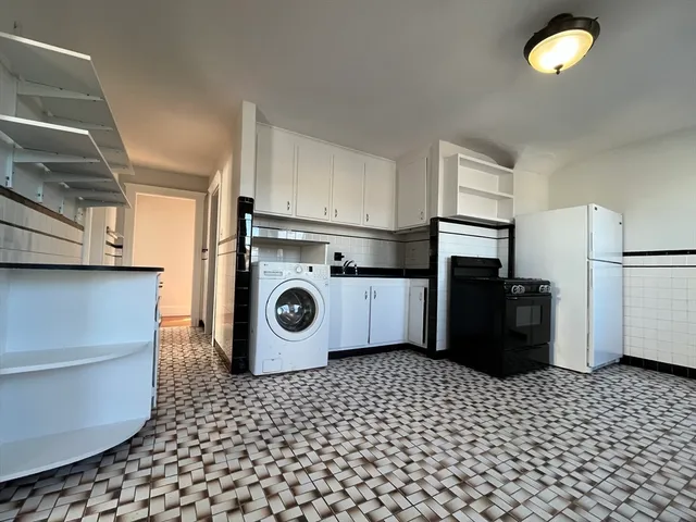 a kitchen with a sink a refrigerator and cabinets