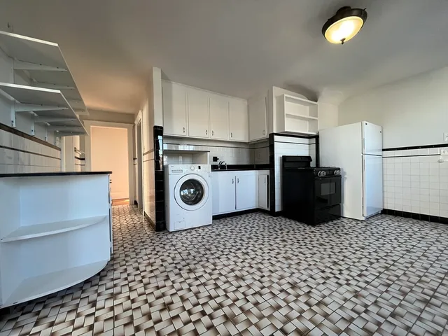a kitchen with a sink a refrigerator and cabinets