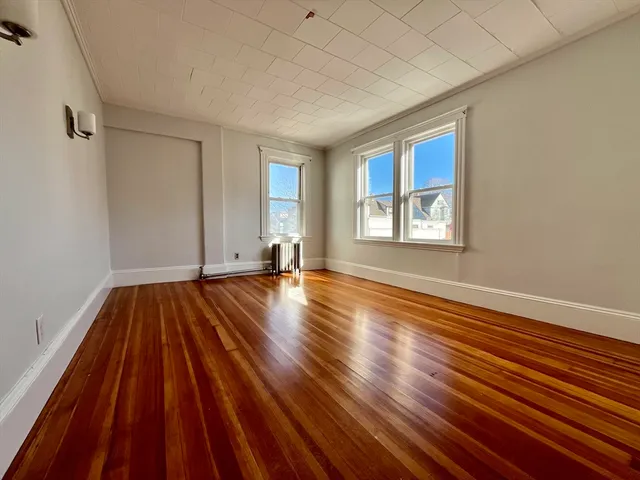 a view of a room with wooden floor and window