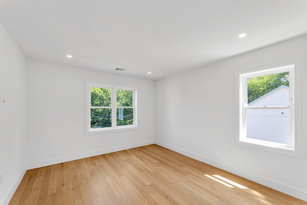 47 Corbett Avenue, Unit 47 Dedham, MA 02026 - Photo 19 of 33 a view of an empty room with wooden floor and a window