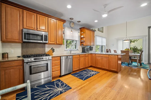a kitchen with stainless steel appliances kitchen island granite countertop a stove a sink and a microwave