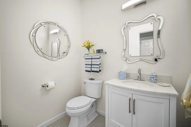 a bathroom with a toilet sink vanity and mirror