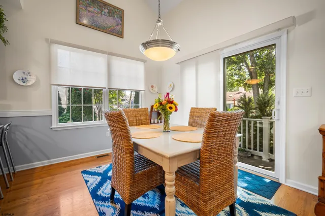 a view of a dining room with furniture a chandelier and wooden floor