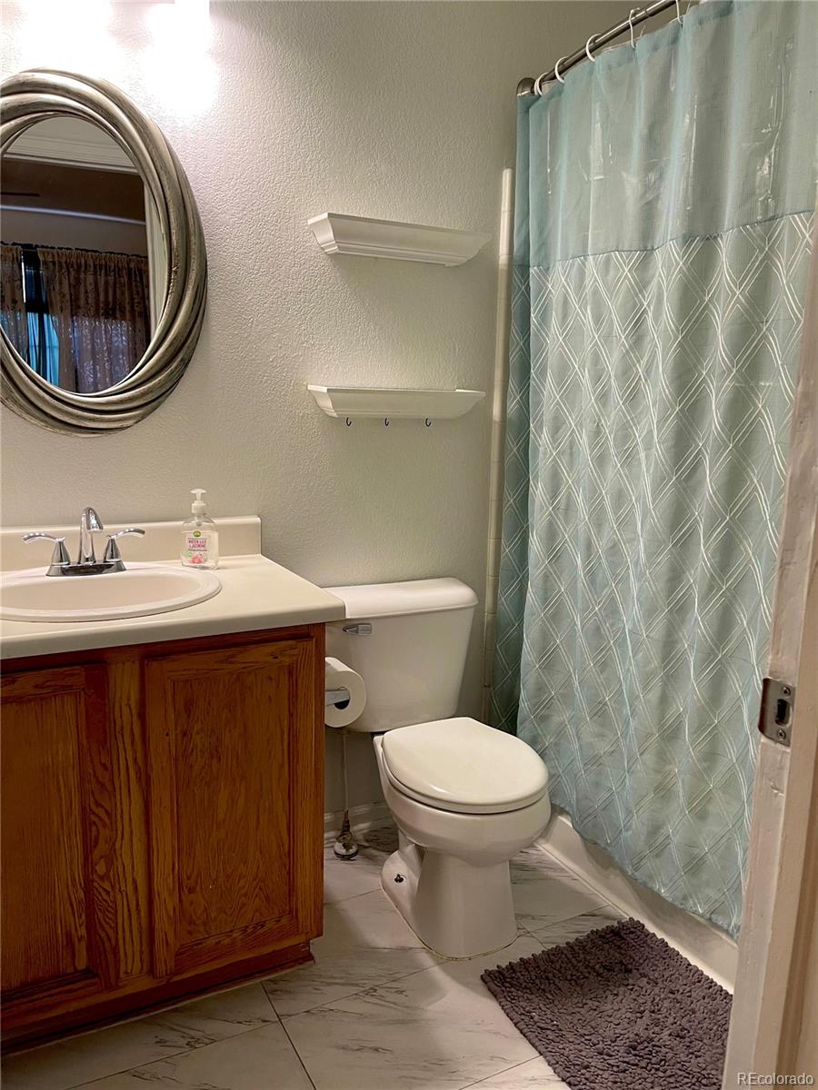 10100 Eudora Court Thornton, CO 80229 - Photo 12 of 17 a bathroom with a sink a toilet and a mirror