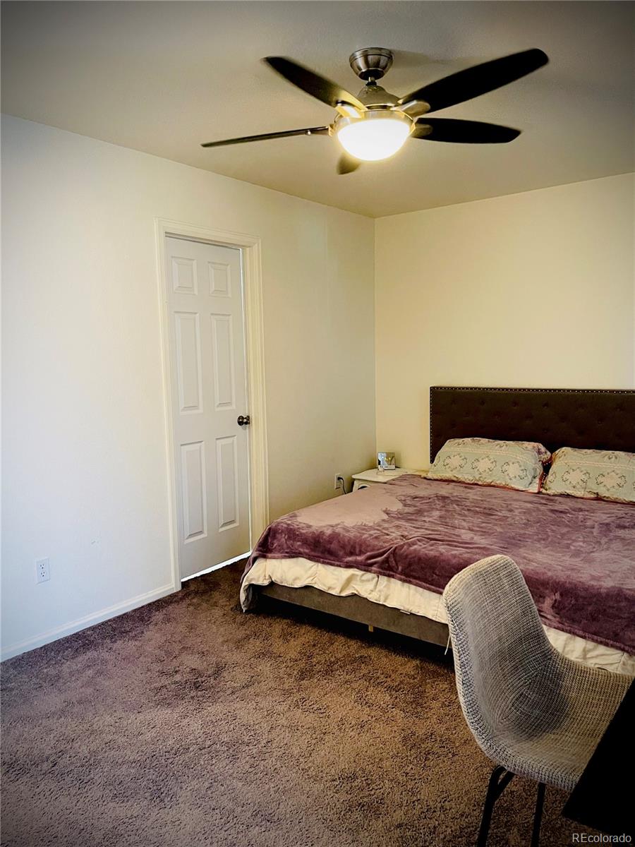 10100 Eudora Court Thornton, CO 80229 - Photo 9 of 17 a bedroom with a bed and a chandelier