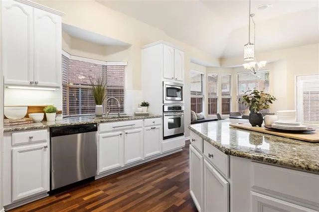 a kitchen with stainless steel appliances granite countertop a sink and dishwasher a stove with wooden floor