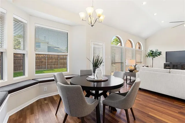 a view of a dining room with furniture a chandelier and wooden floor