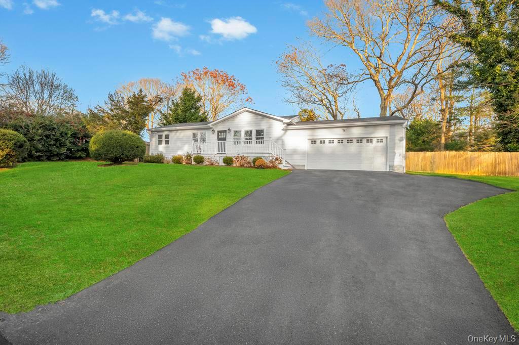 a view of a white house with a big yard and large trees