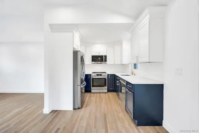 a kitchen with stainless steel appliances a stove top oven a sink and a refrigerator