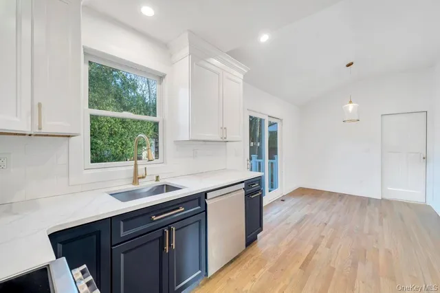 a kitchen with a sink window and cabinets