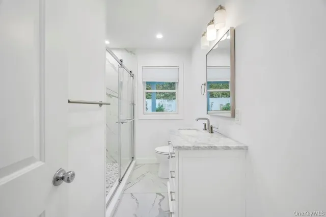 a bathroom with a granite countertop sink a mirror and a shower