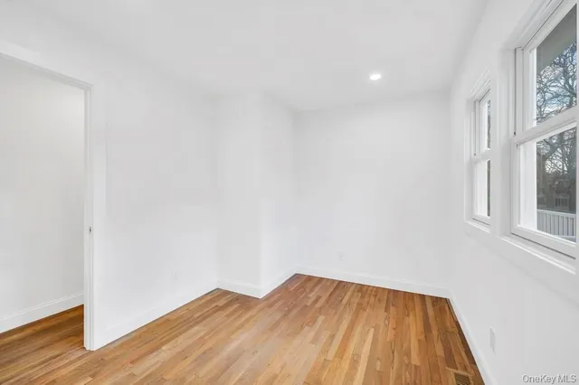 a view of a room with wooden floor and a window