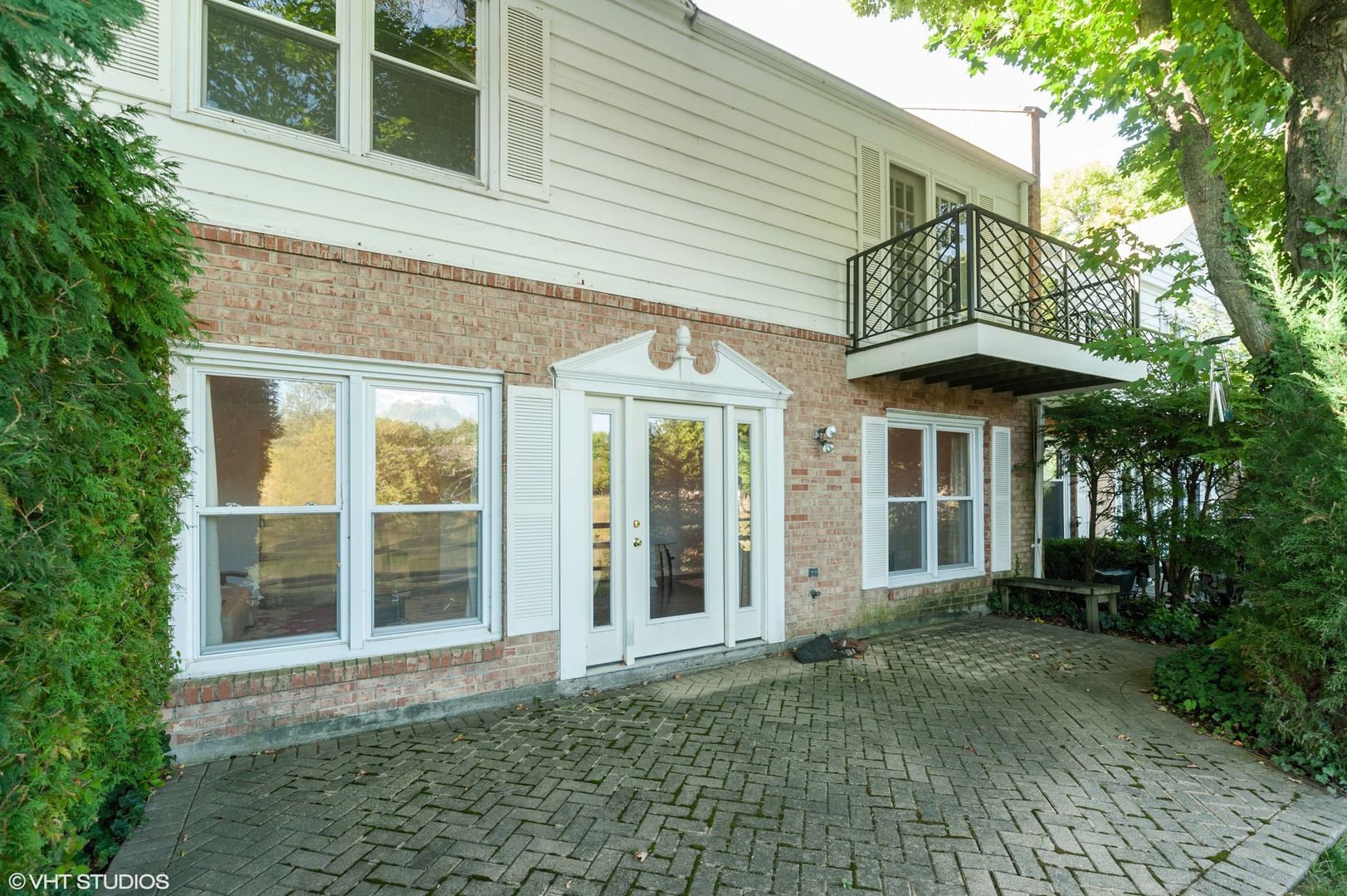 117 Rivershire Lane Lincolnshire, IL 60069 - Photo 12 of 19 a view of a brick house with large windows and a table and chairs