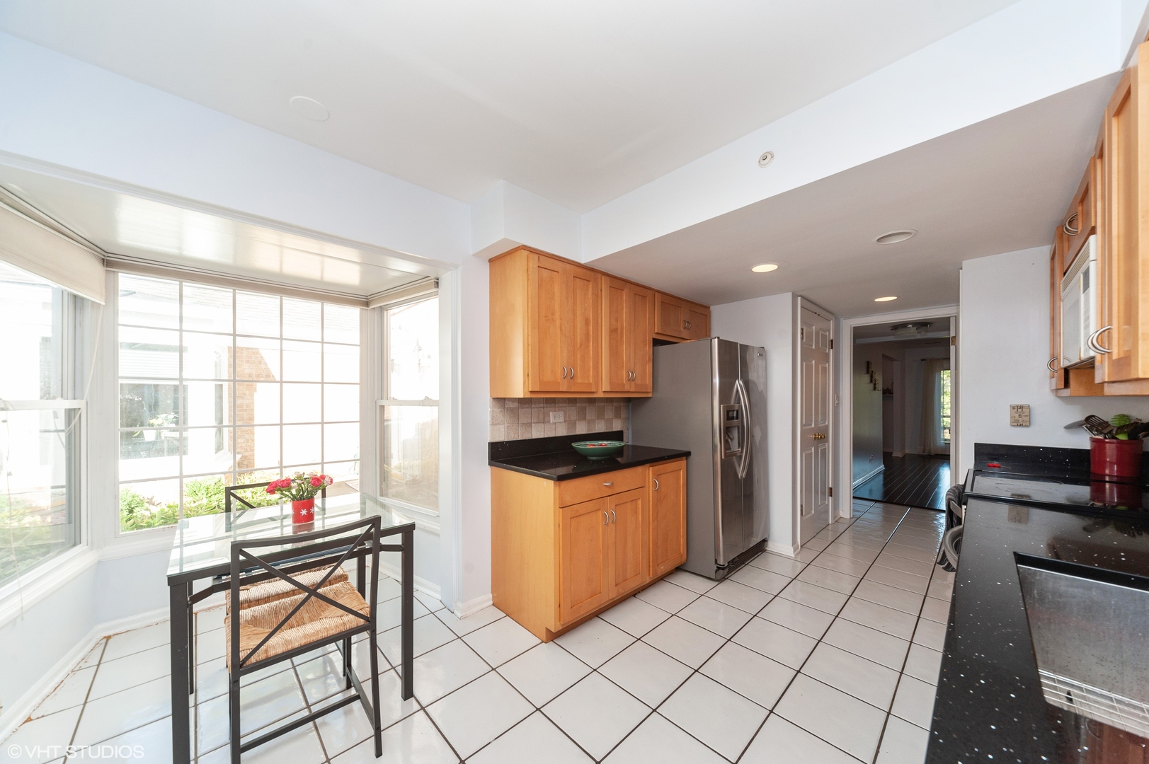 117 Rivershire Lane Lincolnshire, IL 60069 - Photo 3 of 19 a kitchen with stainless steel appliances granite countertop a stove top oven a refrigerator a dining table and chairs with wooden floor