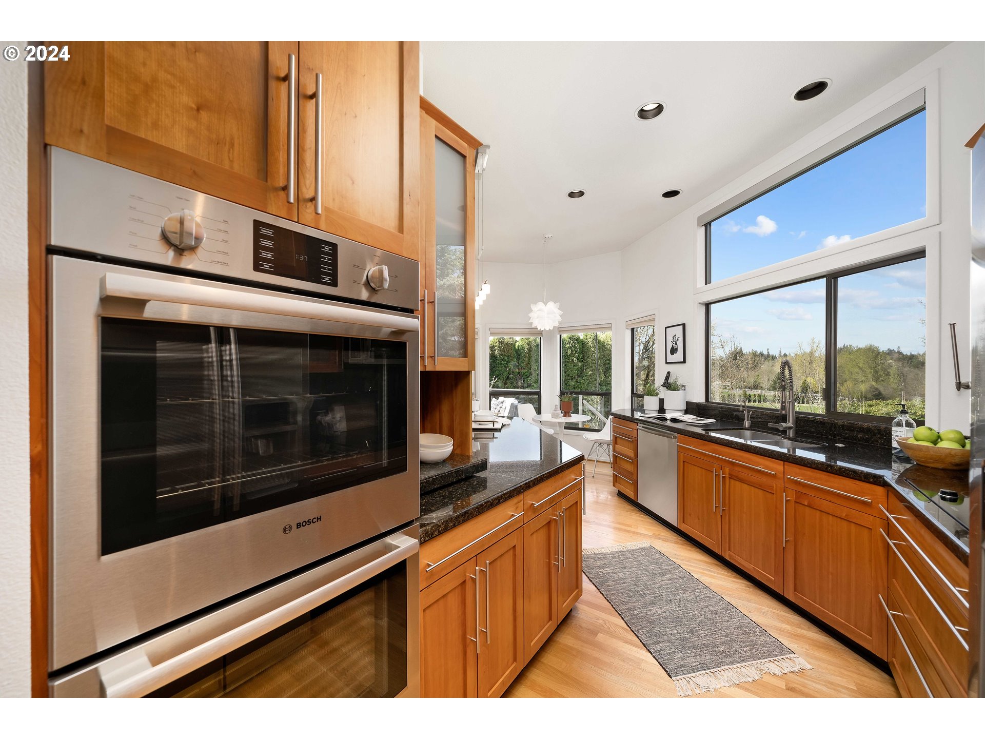 7179 Southwest Arranmore Way Portland, OR 97223 - Photo 12 of 48 a kitchen with stainless steel appliances kitchen island granite countertop a stove a sink and a microwave