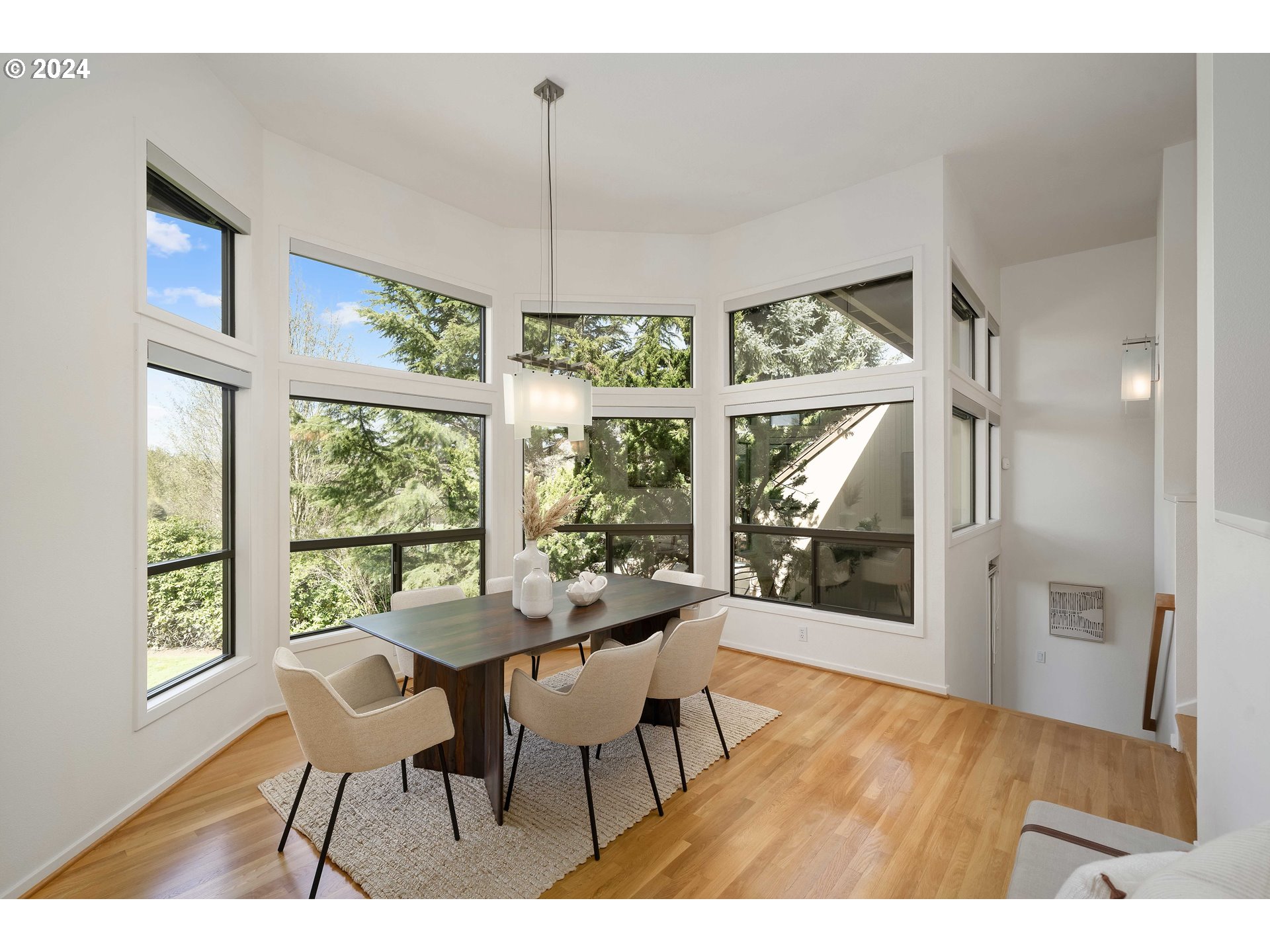 7179 Southwest Arranmore Way Portland, OR 97223 - Photo 9 of 48 a dining room with wooden floor a chandelier a glass table and chairs