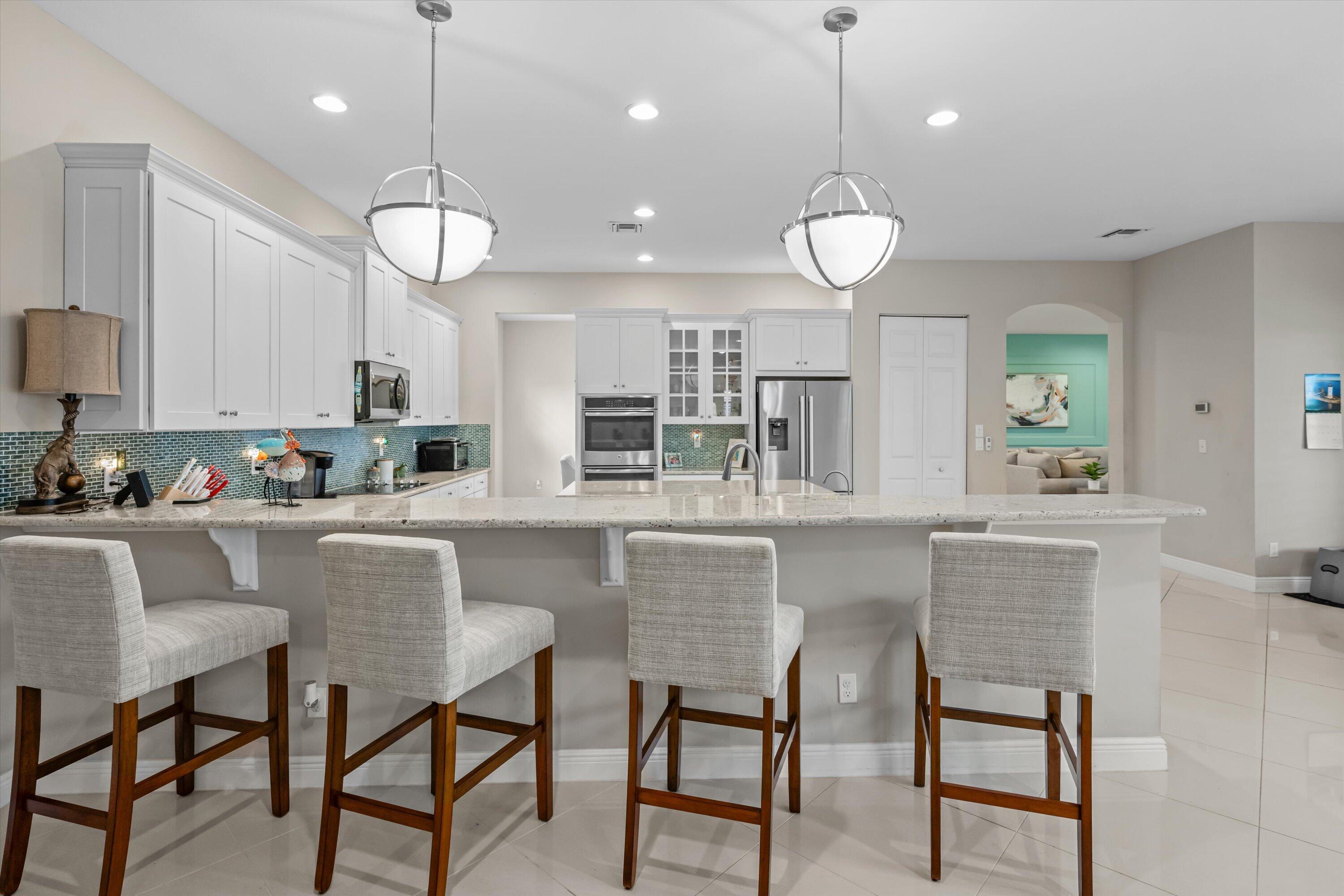 108 Casa Circle Jupiter, FL 33458 - Photo 12 of 53 a kitchen with a dining table chairs and cabinets