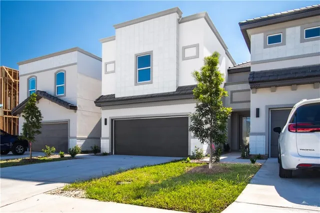 a front view of a house with a yard and garage