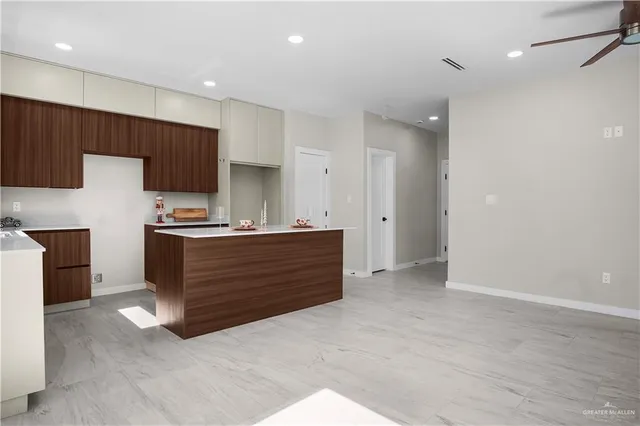 a kitchen with granite countertop wooden cabinets and white stainless steel appliances