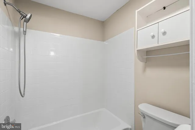 a bathroom with a granite countertop shower and a toilet