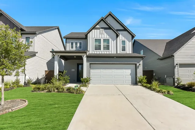 a front view of a house with a yard and garage
