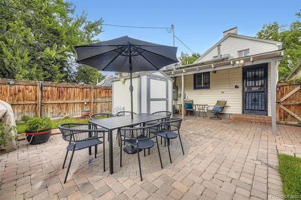 a patio with a table and chairs under an umbrella
