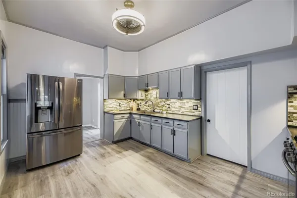 a kitchen with stainless steel appliances granite countertop a refrigerator and a stove top oven