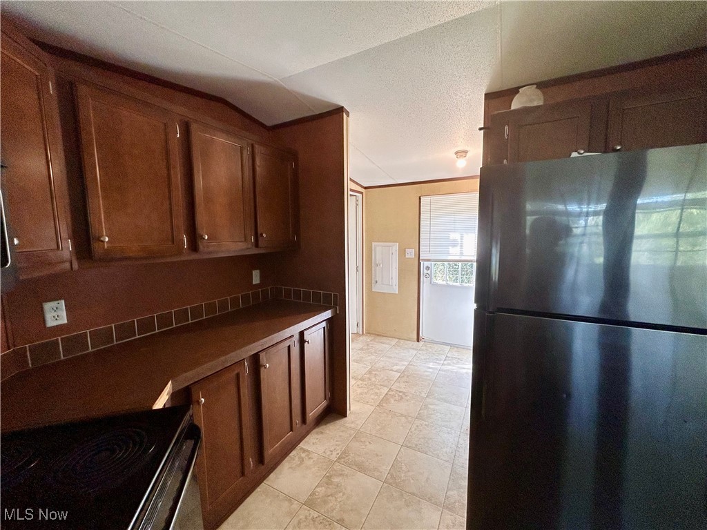 84550 Snyder Road Jewett, OH 43986 - Photo 7 of 21 Kitchen featuring freestanding refrigerator, electric range oven, dark countertops, and brown cabinets