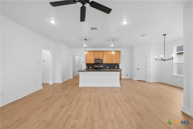 a view of kitchen with refrigerator and microwave